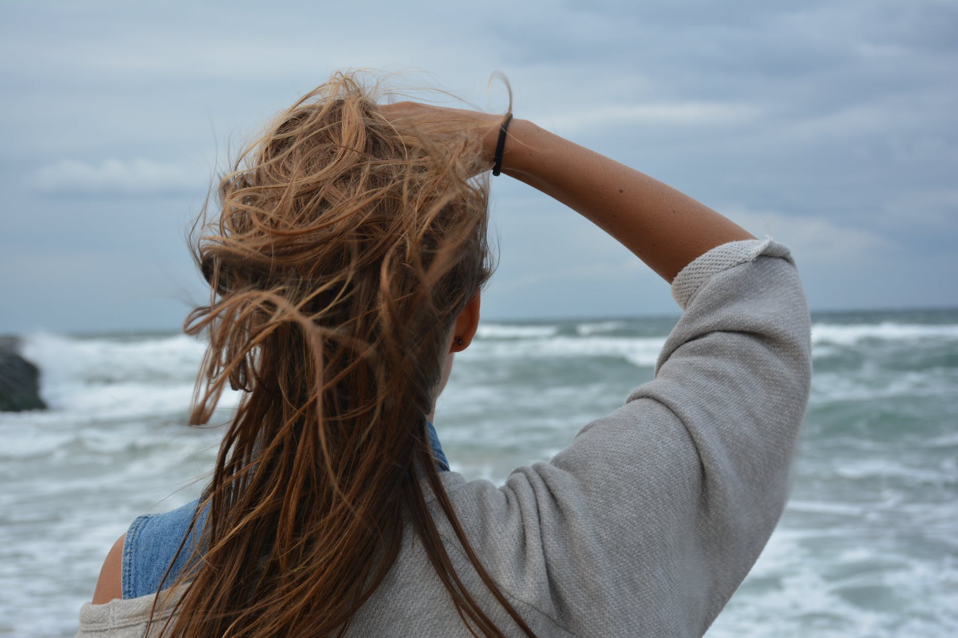 woman facing the ocean during day