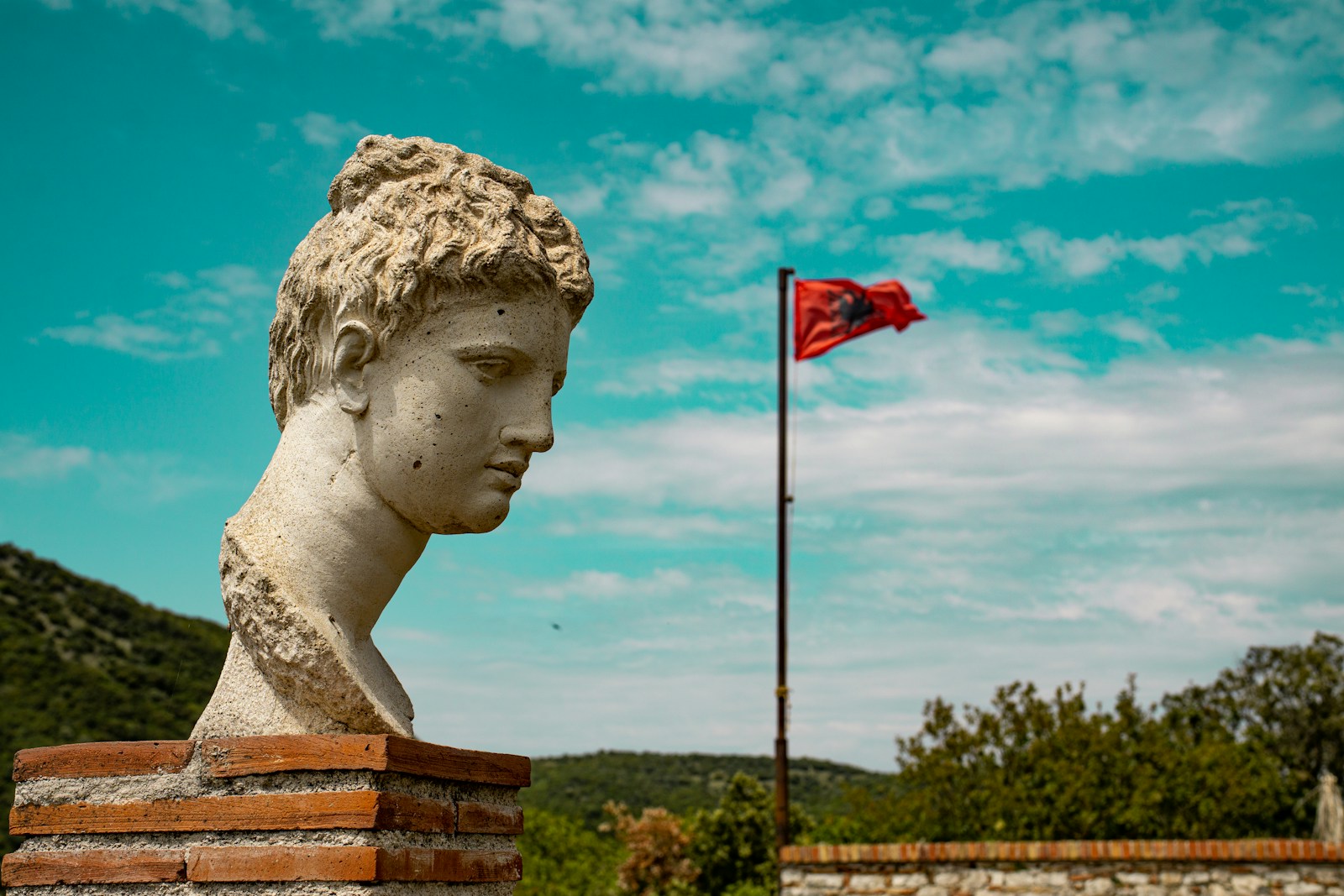 a statue of a person with a flag in the background